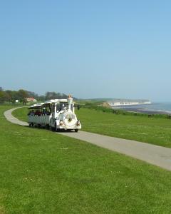 a bus is driving on a road near the ocean at Daisychain Holidays in Bridlington