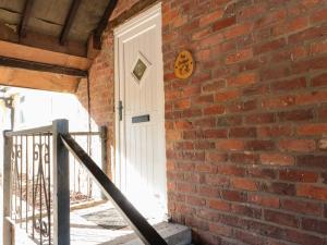 a brick wall with a white door on it at Ivy in Filey