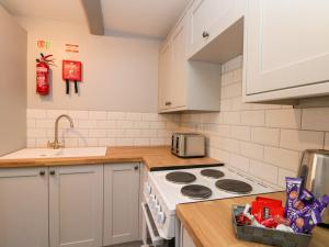 a kitchen with white cabinets and a stove top oven at Ivy in Filey
