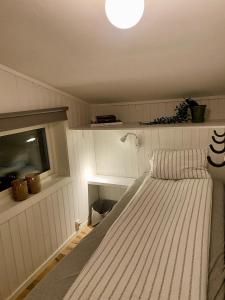 a bedroom with a bed with a light on the ceiling at Flott beliggenhet svært sentralt i sentrum in Svolvær +16 photos