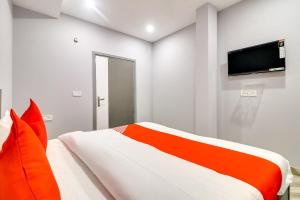 ニューデリーにあるCollection O Preet Vihar Metro Station Formerly Hotel Dream Palaceのベッドと薄型テレビのある寝室