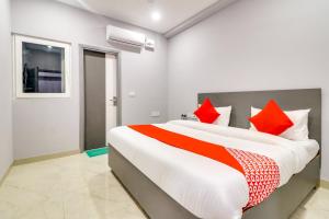 ニューデリーにあるCollection O Preet Vihar Metro Station Formerly Hotel Dream Palaceのベッドルーム1室(大型ベッド1台、赤い枕付)