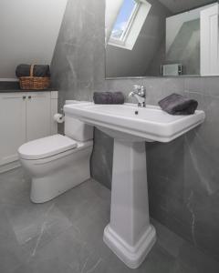 a bathroom with a white sink and a toilet at Cherrywood-luxe retreat in the Southern Highlands in Exeter +86 photos