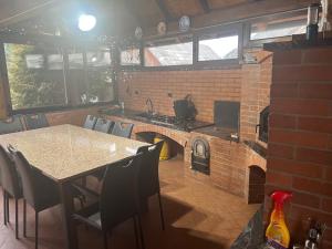 a kitchen with a brick fireplace and a table and chairs at Villa Mery in Moisei