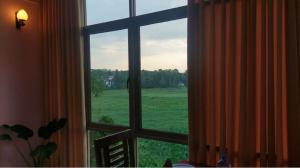 a window with a view of a green field at Old Fashion Hotel in Minuwangoda