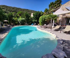 a swimming pool with blue water in a yard at Villa Petra Bianca Suites & Chambres in Bonifacio