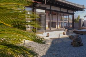 a building with a palm tree in front of it at Mageme House JUN-CB0102 in Kujukuri