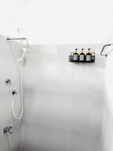 a white bathroom with a shower and a sink at Raa Pala Lake Resort in Anuradhapura