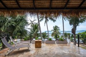 a resort balcony with chairs and palm trees at Koh Mak White Sand Beach in Ko Mak