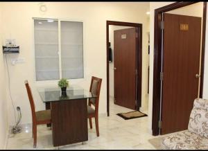 a room with a table and chairs and a door at Family Friendly Guest House in Bengaluru
