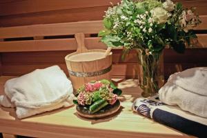 una mesa con un jarrón de flores y un jarrón de flores en Hotel Wilgenhof, en Maaseik