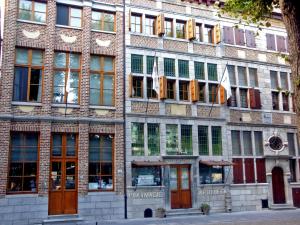 a large brick building with many windows on a street at Hotel Wilgenhof in Maaseik