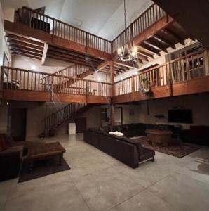 a large living room with a staircase and a couch at Gite Le Paradis in Orcival