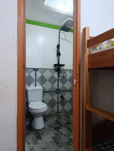 a bathroom with a toilet in a room at 3kid's Homestay white in General Luna