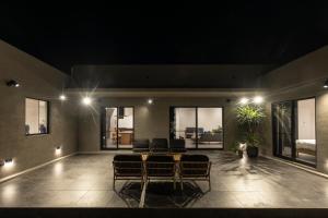 a living room with a table and chairs and lights at THE HERO VILLA 米原ビーチリゾートishigaki in Ishigaki Island