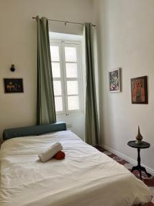 Un dormitorio con una cama blanca con una ventana. en Enjoy and Relax at the Blu House, en Sliema