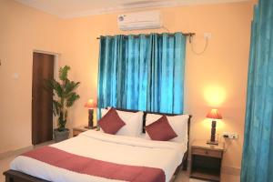 a bedroom with a bed with blue drapes at 2nd Innings Calangute Private in Calangute +28 photos