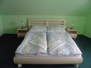 ein Bett mit Bettwäsche aus Kunststoff und Kissen darauf in der Unterkunft Penzion U Modrého Slona in Franzensbad