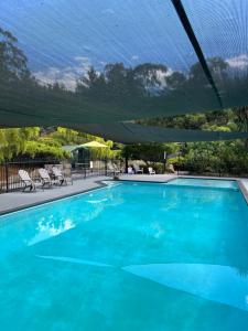 a large blue swimming pool under an umbrella at Panorama Retreat & Resort in Kalorama