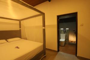 尼甘布AMcroos的一间卧室配有一张床,浴室设有卫生间