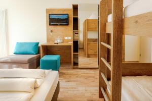 ルストにあるホテル ミトスの二段ベッドとソファが備わる小さな客室です。