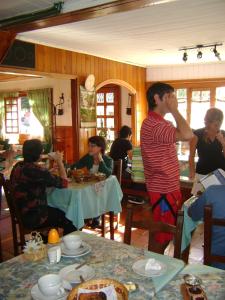 a group of people sitting at tables in a restaurant at Hosteria Cumelen in San Martín de los Andes +28 photos