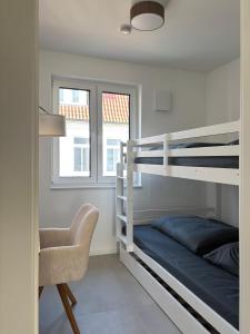 a bedroom with two bunk beds and a chair at Oldenburg City Apartments in Oldenburg