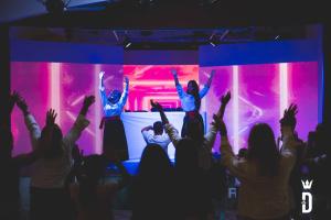 a group of people raising their arms in front of a stage at Villaggio Camping Duca Amedeo in Martinsicuro