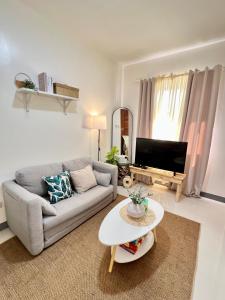 a living room with a couch and a table at Cozy Escape Calaca in Calaca