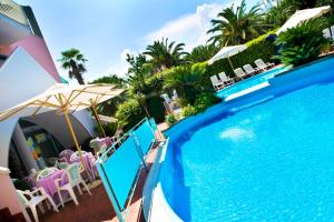 a swimming pool with chairs and umbrellas next to a resort at Residence Mediterraneo in San Benedetto del Tronto