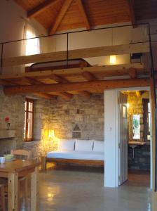 1 dormitorio con 1 cama en una pared de piedra en Kastraki Art Houses, en Kousounárion