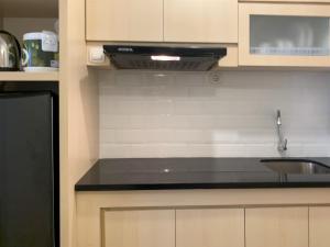 a kitchen with a sink and a stove at Simply Studio at Tokyo Riverside PIK 2 Apartment By Travelio in Rawalembang +10 photos