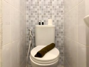 a bathroom with a toilet with a roll of toilet paper at Simply Studio at Tokyo Riverside PIK 2 Apartment By Travelio in Rawalembang +11 photos