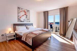 a bedroom with a bed and a large window at Apartments Casa Barbara in Rab