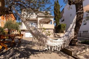 a hammock hanging from a tree in a courtyard at Apartments Casa Barbara in Rab