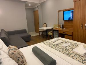 a room with a bed and a couch and a television at Riverland Suites Apart Hotel in Istanbul