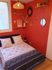 a bedroom with a bed with a red wall at studio cosy idéalement situé parking privé in Ajaccio +1 photo