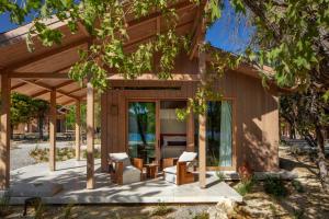 a wooden house with a porch and chairs at Ahama in Yaniklar