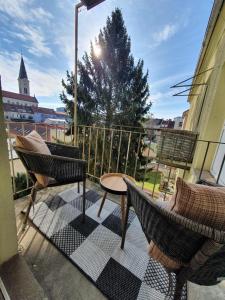 a balcony with two chairs and a table on a balcony at Charmante Wohnung in Innenstadtlage in Graz