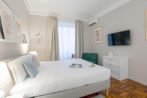 ローマにあるPiramide Deluxe Apartmentの白いベッドルーム(白いベッド1台、白いソファ付)