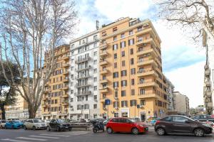 ローマにあるPiramide Deluxe Apartmentの前に車が駐車されている高い建物