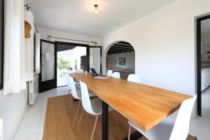 a dining room with a wooden table and white chairs at Isla Bonita Rental Home Moraira in Moraira