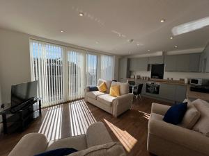 a living room with two couches and a kitchen at Stunning 2 bedroom flat for 5 people overlooking the sea 2A in Felixstowe
