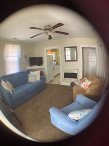 a living room with two blue couches and a ceiling fan at Four Seasons in Colonial Beach