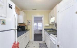 a kitchen with white cabinets and a white refrigerator at Four Seasons in Colonial Beach