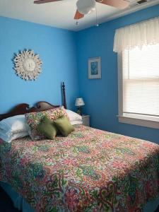 a blue bedroom with a bed with a colorful bedspread at Four Seasons in Colonial Beach