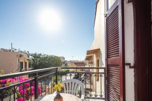 レティムノ・タウンにあるMarylee's studio Old town Rethymno standard studio Adults Onlyのバルコニーのテーブルに座る花瓶 +8枚の写真