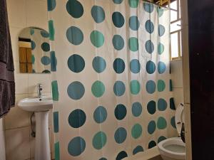 Un baño con una cortina de ducha verde y blanca. en NL residence - Kampala, en Kampala