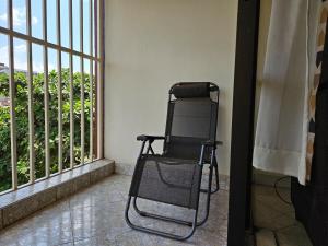 una silla negra sentada frente a una ventana en NL residence - Kampala, en Kampala