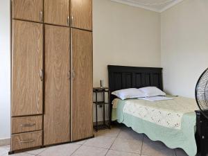 Un dormitorio con una cama y armarios de madera. en NL residence - Kampala, en Kampala